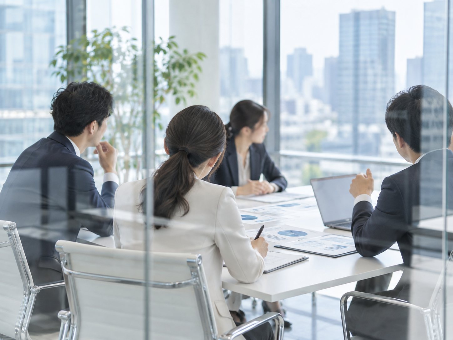 ガラス張りの会議室で議論するビジネスパーソン